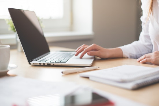 Person scrollt am Laptop
