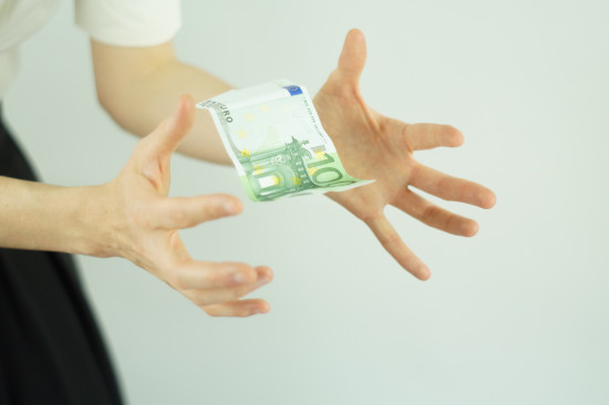 Geldschein zwischen zwei Händen
