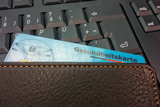 Krankenversicherungskarte liegt auf Tastatur Krankenversicherungskarte liegt auf Tastatur