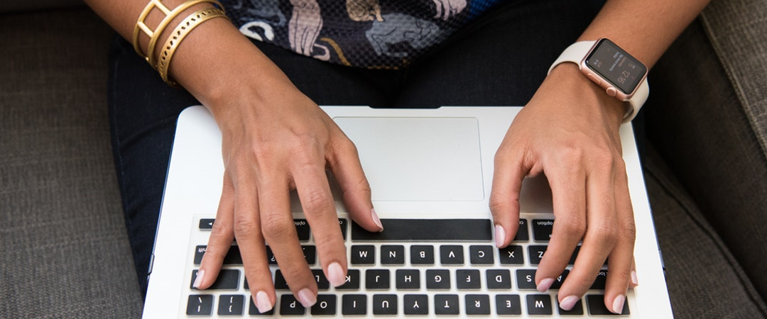 Person tippt auf Laptoptastatur