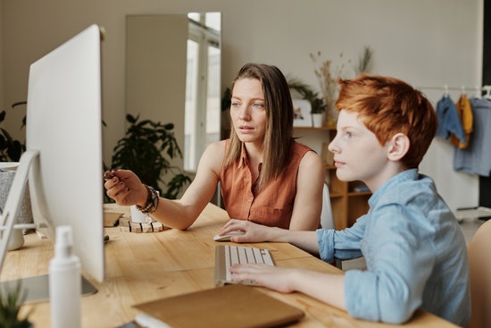 Ein Kind bekommt Nachhilfe am Computer Ein Kind bekommt Nachhilfe am Computer