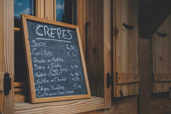 Ein Schild mit Preisen für ein Crêpe-Geschäft Ein Schild mit Preisen für ein Crêpe-Geschäft
