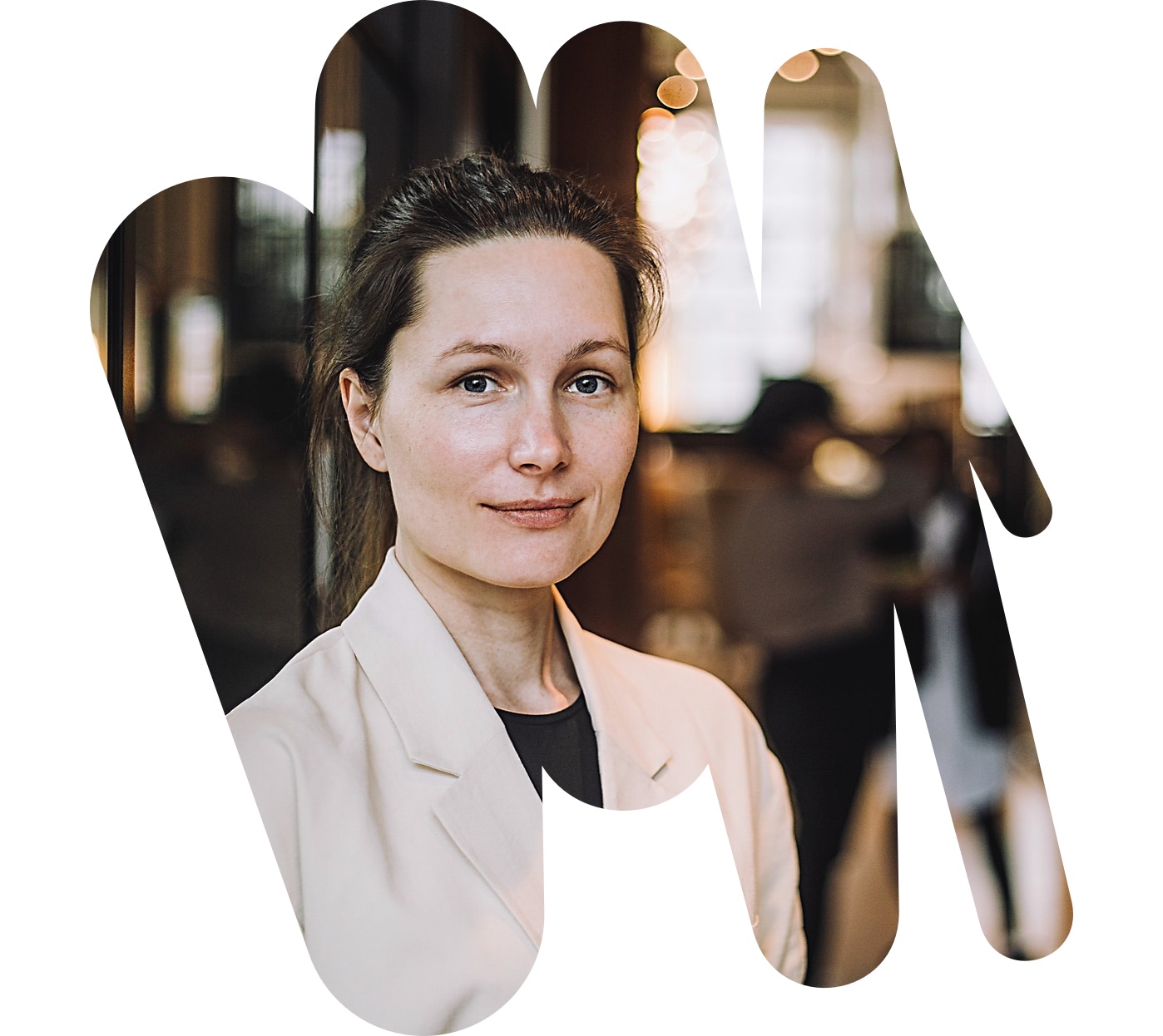 Eine Frau im Blazer schaut freundlich in die Kamera