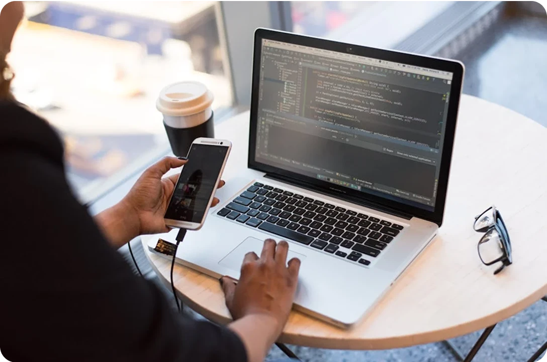 Developer with laptop and digital interface graphics Developer working on a laptop with abstract digital elements and code in the background
