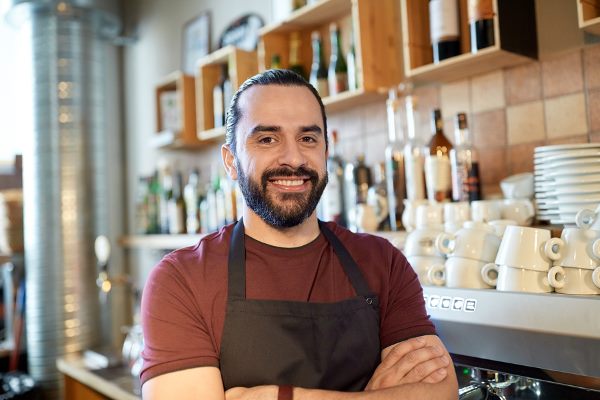 Clear strategy man smiling at the camera in front of his cafe